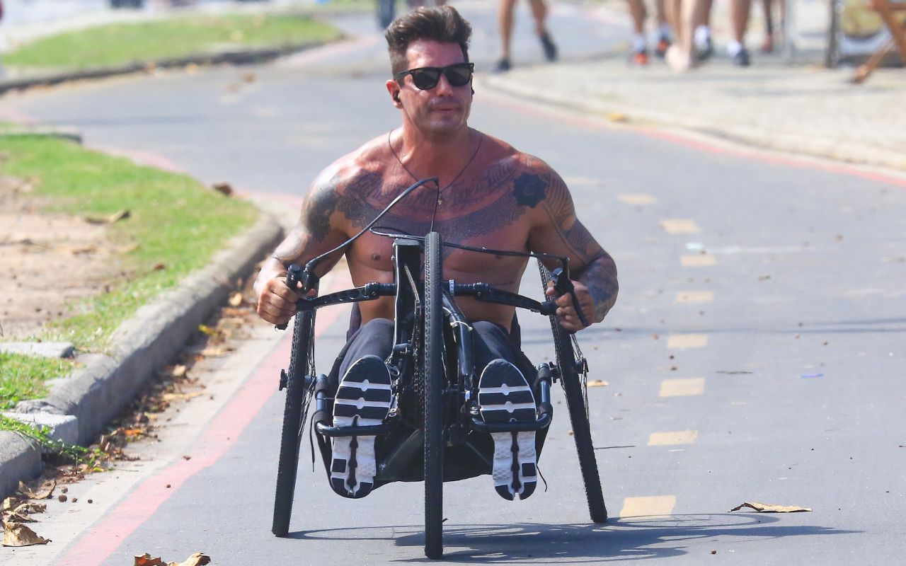 Fernando Fernandes pedala na orla da Barra após cirurgia- OFuxico